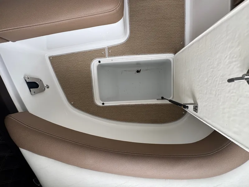 Slide: The Image of An open storage compartment on a 2015 Cobalt 296 boat with cushioned seating. - 17