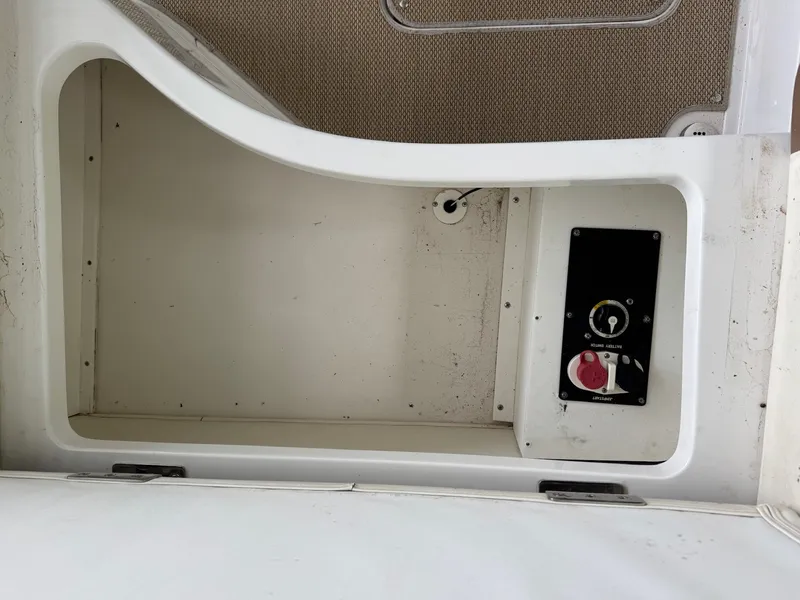 Slide: The Image of An open storage compartment with a control panel and switches inside a boat. - 22