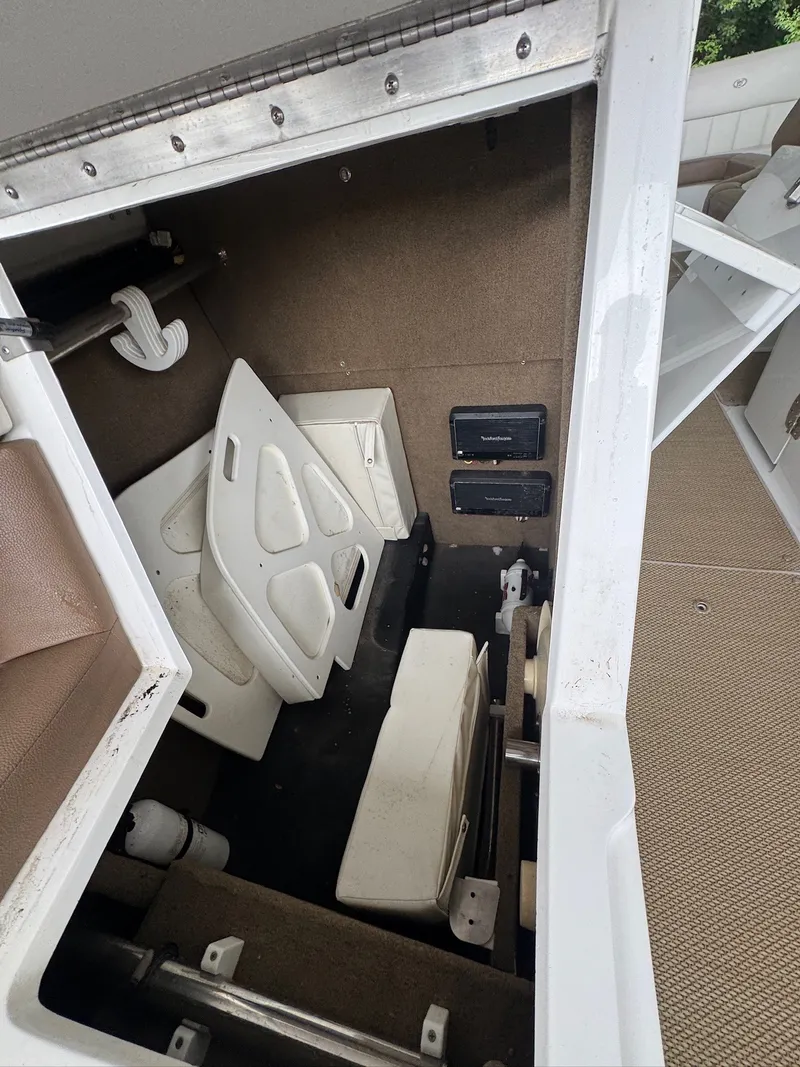 Slide: The Image of A storage compartment inside a 2015 Cobalt 296 boat with folding chairs and equipment. - 19