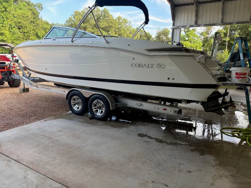 Slide: The Image of A 2015 Cobalt 296 boat on a trailer in a covered storage area. - 2