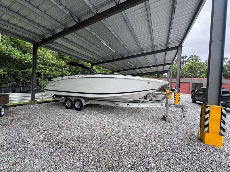 The Image of A 2015 Cobalt 296 boat on a trailer under a covered area. - 0