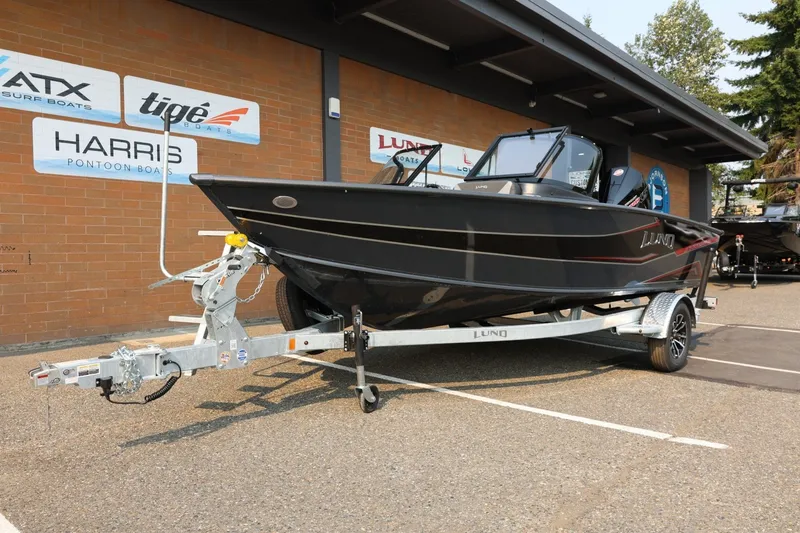 Slide: The Image of A black Lund 1875 Crossover XS boat on a trailer in front of a building. - 14