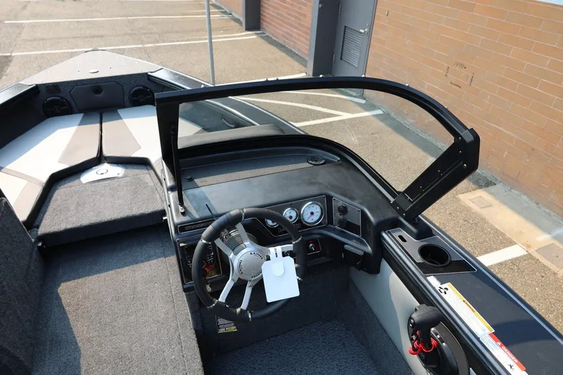 Slide: The Image of The image shows the cockpit of a Lund 1875 Crossover XS boat with a modern helm. - 32