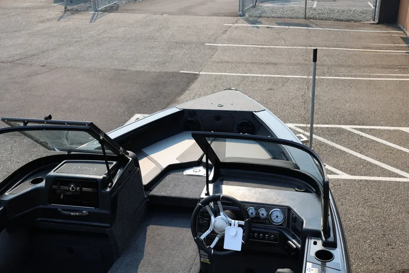 Slide: The Image of The image shows the cockpit of a Lund 1875 Crossover XS boat with steering and instruments. - 50
