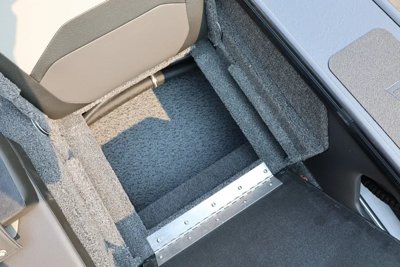 Slide: The Image of An open storage compartment with gray carpeting in a boat. - 46