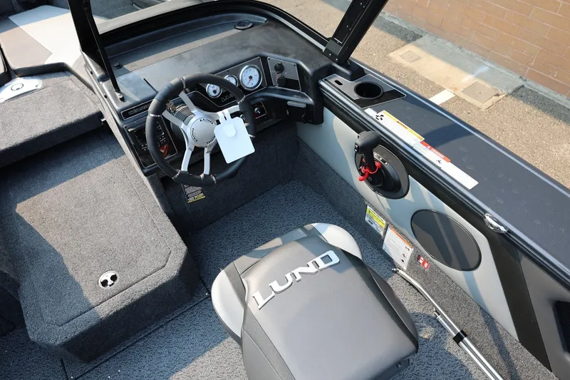 Slide: The Image of The image shows the cockpit of a 2027 Lund 1875 Crossover XS boat with a modern helm. - 31