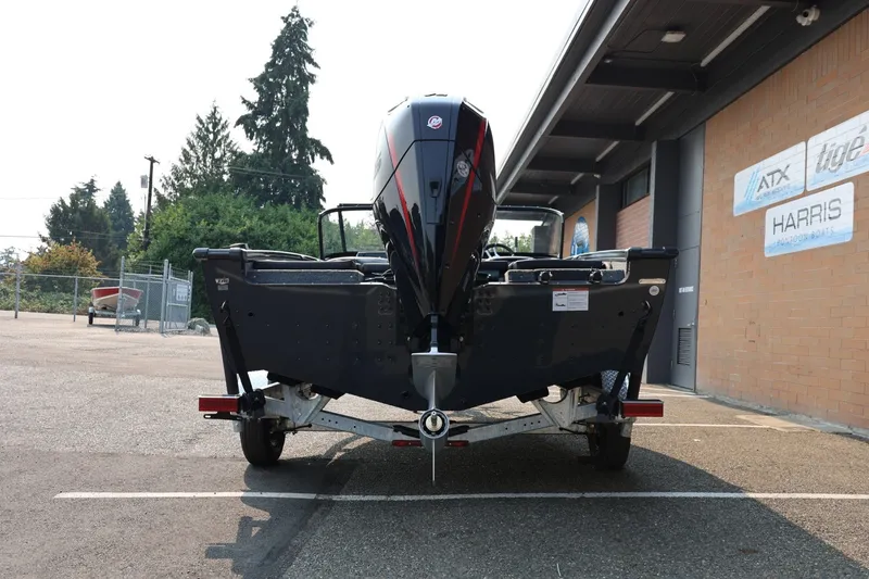 Slide: The Image of Rear view of a Lund 1875 Crossover XS boat on a trailer, parked in front of a building. - 6