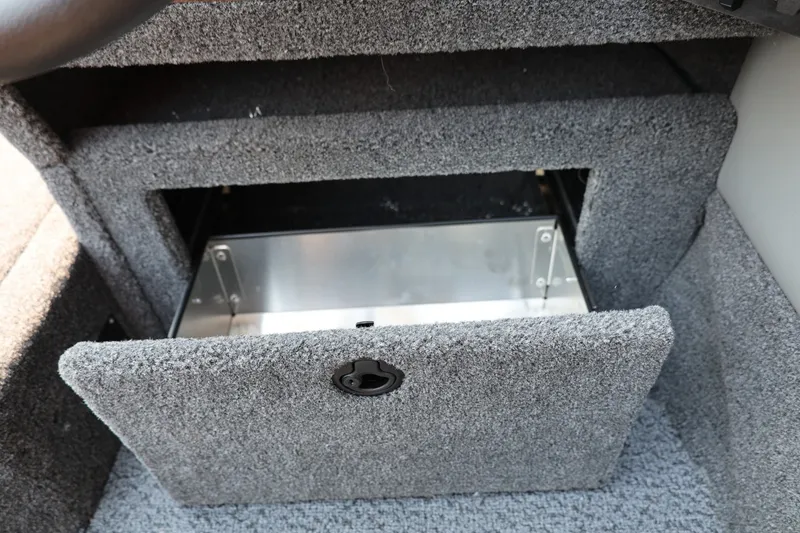 Slide: The Image of An open storage compartment with gray carpeting and a metal compartment inside. - 36