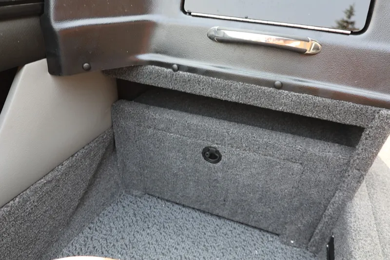 Slide: The Image of Interior view of a boat with gray carpeted flooring and a small storage compartment. - 29