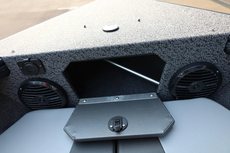 Slide: The Image of The image shows the bow of a Lund 1875 Crossover XS boat with speakers and storage space. - 20
