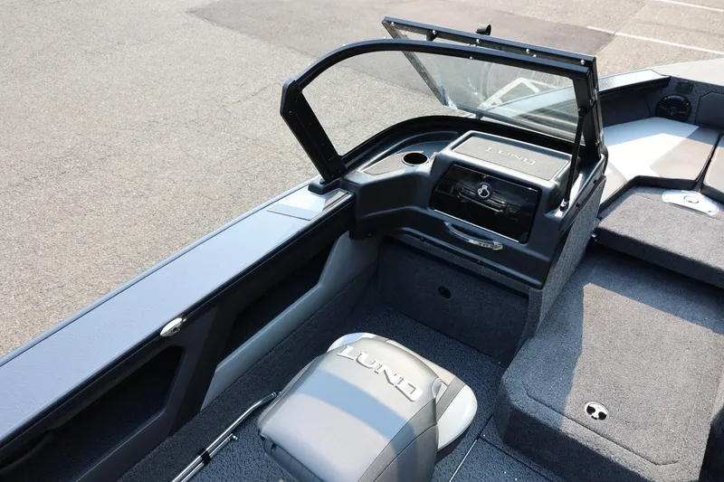 Slide: The Image of The image shows the cockpit of a Lund 1875 Crossover XS boat with gray upholstery and a helm station. - 27