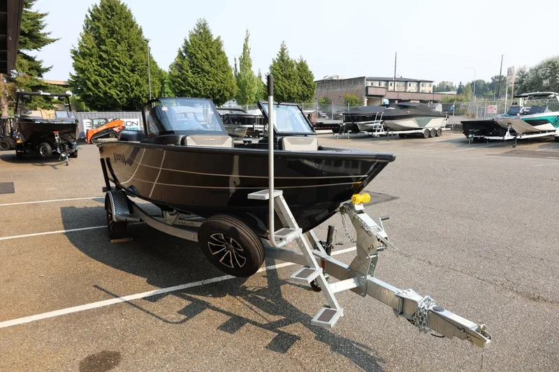 Slide: The Image of A 2027 Lund 1875 Crossover XS boat on a trailer in a parking lot. - 9