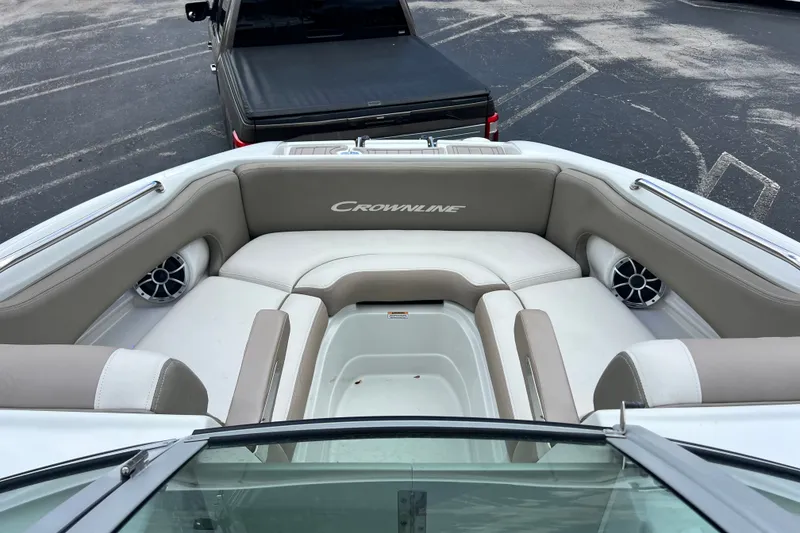 Slide: The Image of 2023 Crownline Eclipse E235 XS boat interior with cushioned seating and speakers. - 62