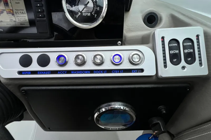 Slide: The Image of Control panel of 2023 Crownline Eclipse E235 XS boat with various switches and gauges. - 70