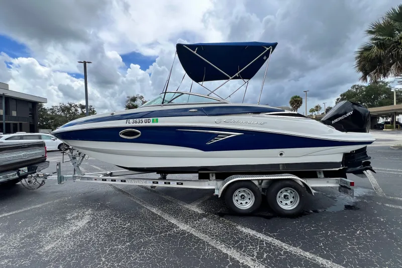 Slide: The Image of 2023 Crownline Eclipse E235 XS boat on trailer, parked outdoors under cloudy sky. - 37