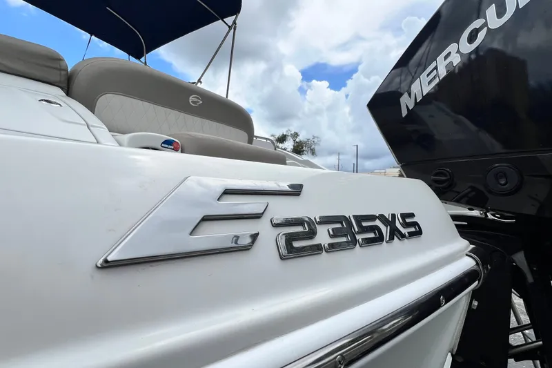 Slide: The Image of 2023 Crownline Eclipse E235 XS boat with Mercury engine, under a cloudy sky. - 39