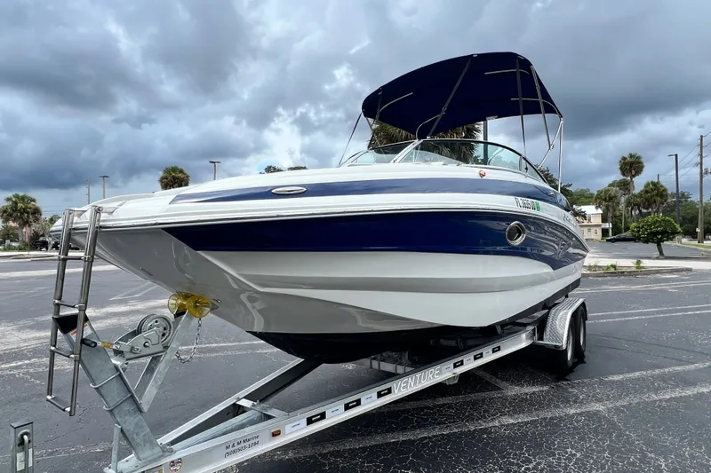 Slide: The Image of 2023 Crownline Eclipse E235 XS boat on trailer under cloudy sky. - 36
