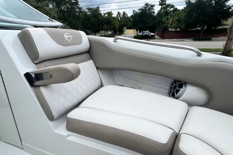 Slide: The Image of 2023 Crownline Eclipse E235 XS boat interior with cushioned seating and speaker. - 75