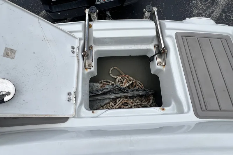 Slide: The Image of Open storage compartment on 2023 Crownline Eclipse E235 XS boat with rope and anchor. - 78