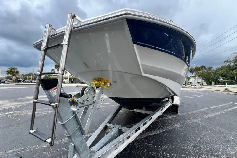 Slide: The Image of 2023 Crownline Eclipse E235 XS boat on trailer under cloudy sky. - 35