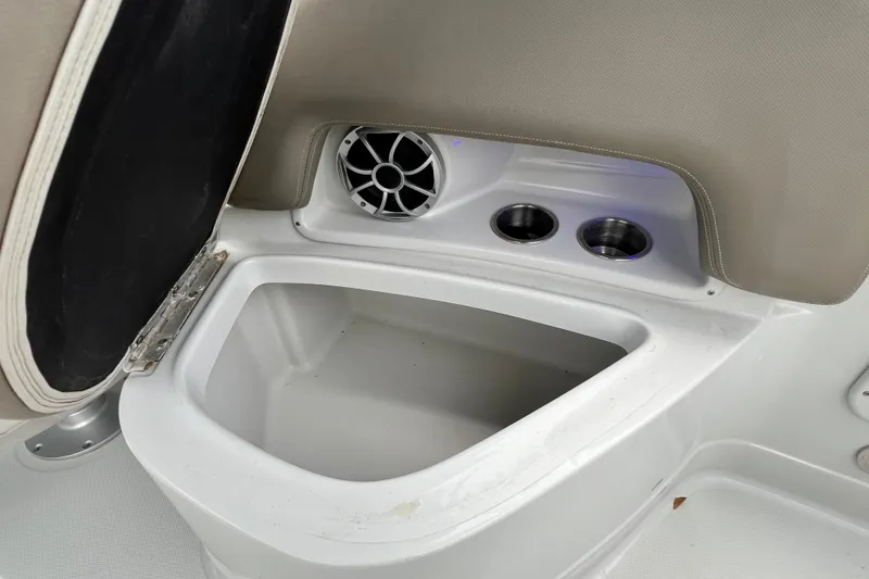 Slide: The Image of 2023 Crownline Eclipse E235 XS boat interior with storage compartment and cup holders. - 90