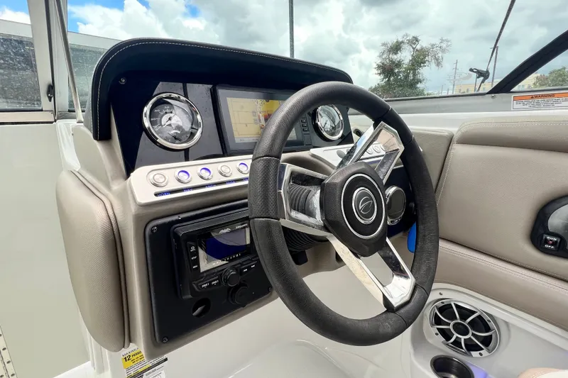 Slide: The Image of 2023 Crownline Eclipse E235 XS boat dashboard with steering wheel and gauges. - 68