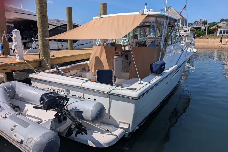 Slide: The Image of 2000 Pursuit 3400 Express boat docked with inflatable dinghy attached. - 30