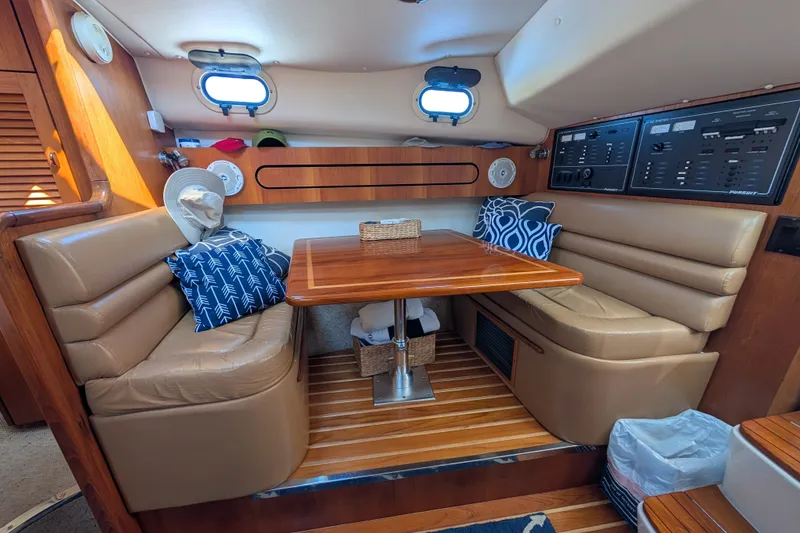 Slide: The Image of Interior of 2000 Pursuit 3400 Express yacht with cozy seating and wooden table. - 11
