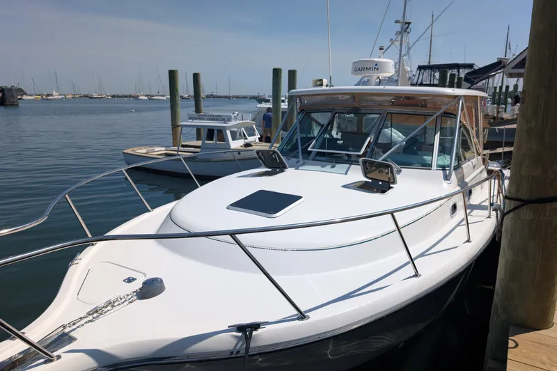Slide: The Image of 2000 Pursuit 3400 Express boat docked at marina, featuring sleek design and Garmin equipment. - 25