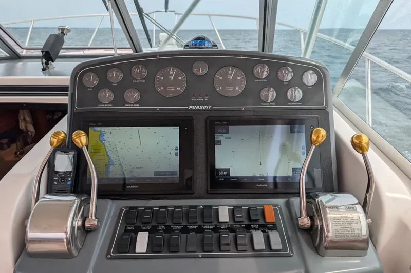 Slide: The Image of Control panel of a 2000 Pursuit 3400 Express boat with navigation screens and gauges. - 40