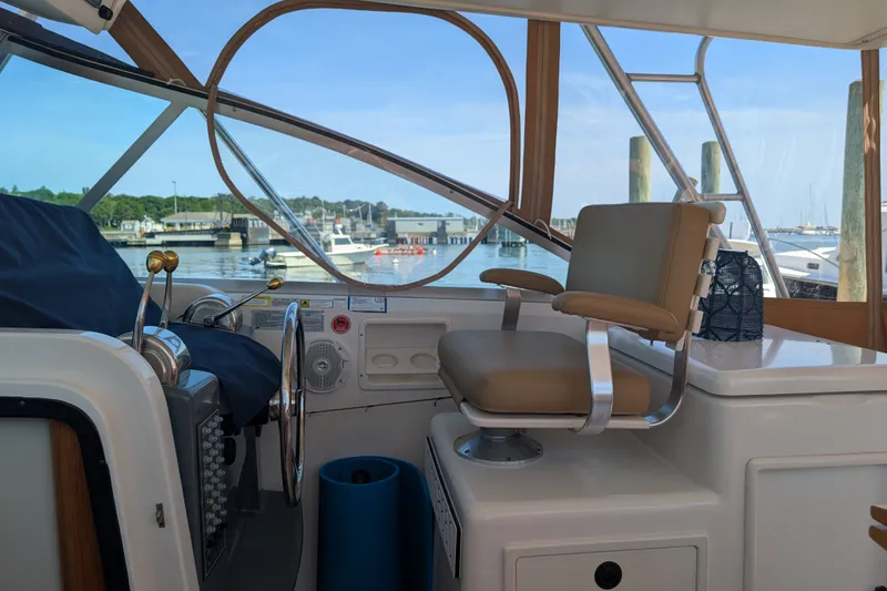 Slide: The Image of Helm of 2000 Pursuit 3400 Express boat with marina view. - 19