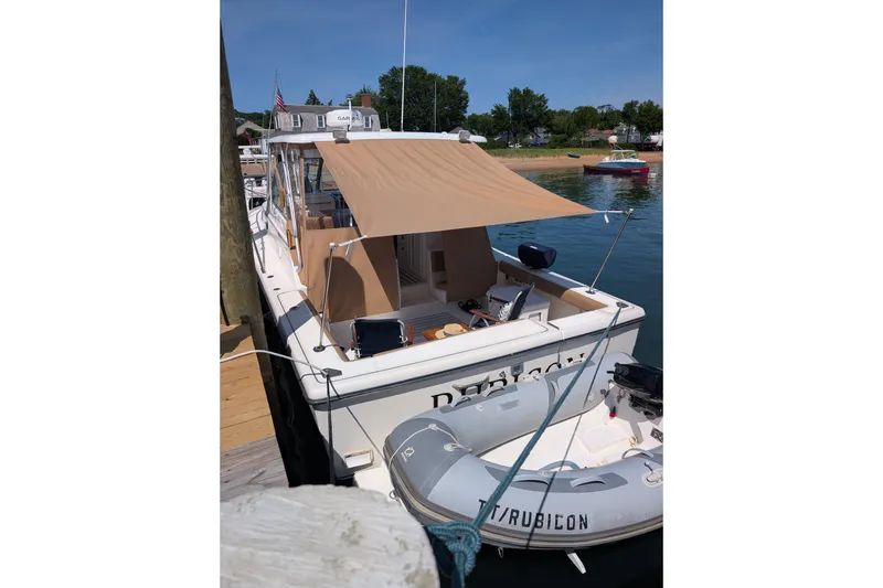 Slide: The Image of 2000 Pursuit 3400 Express boat docked with canopy and inflatable dinghy. - 24