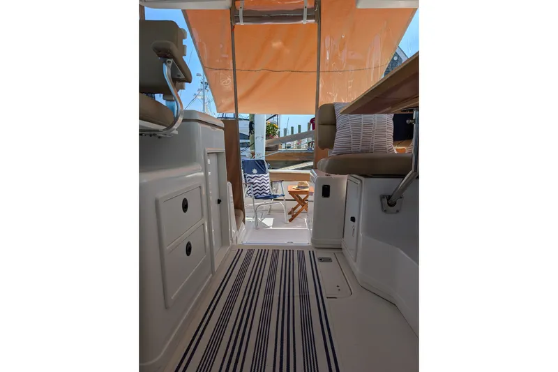Slide: The Image of Interior view of a 2000 Pursuit 3400 Express boat with striped flooring and seating. - 22