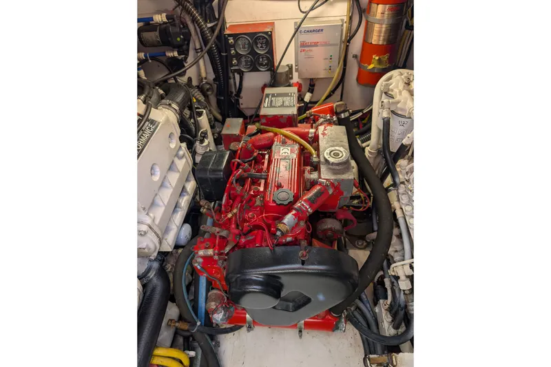 Slide: The Image of Engine compartment of a 2000 Pursuit 3400 Express boat, featuring a red engine. - 35