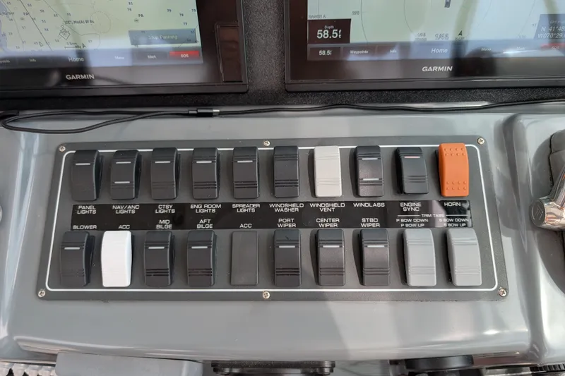 Slide: The Image of Control panel of a 2000 Pursuit 3400 Express boat with labeled switches and Garmin displays. - 39
