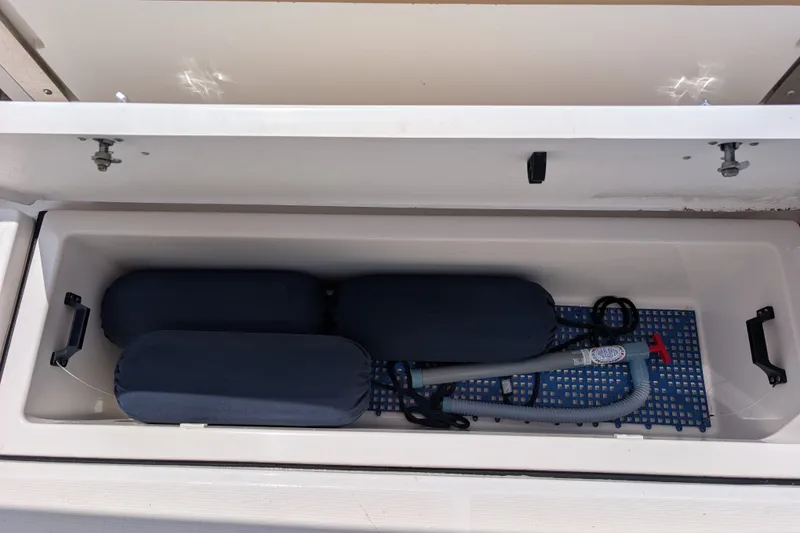 Slide: The Image of Storage compartment of 2000 Pursuit 3400 Express boat with fenders and pump. - 47