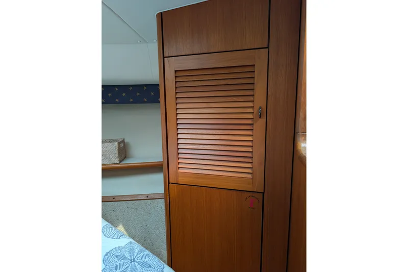 Slide: The Image of Interior of 2000 Pursuit 3400 Express boat featuring wooden cabinetry and cozy decor. - 50
