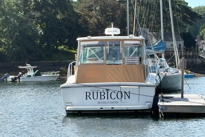 Slide: The Image of 2000 Pursuit 3400 Express boat named "Rubicon" docked at a marina. - 2