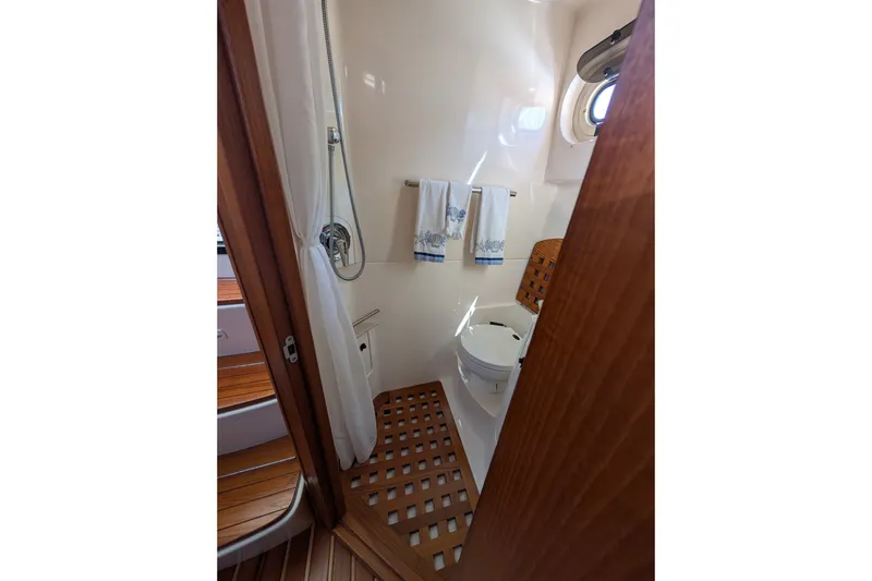 Slide: The Image of Bathroom interior of 2000 Pursuit 3400 Express boat, featuring shower and toilet. - 14