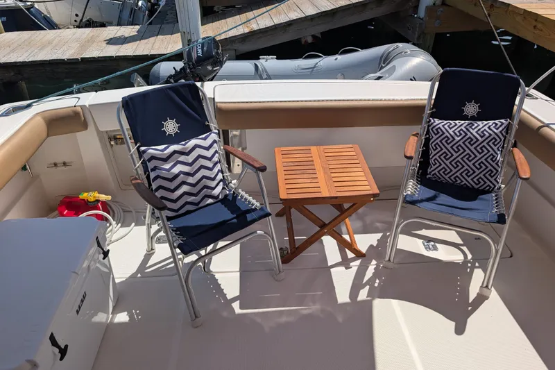 Slide: The Image of 2000 Pursuit 3400 Express boat deck with chairs and table, docked at marina. - 26
