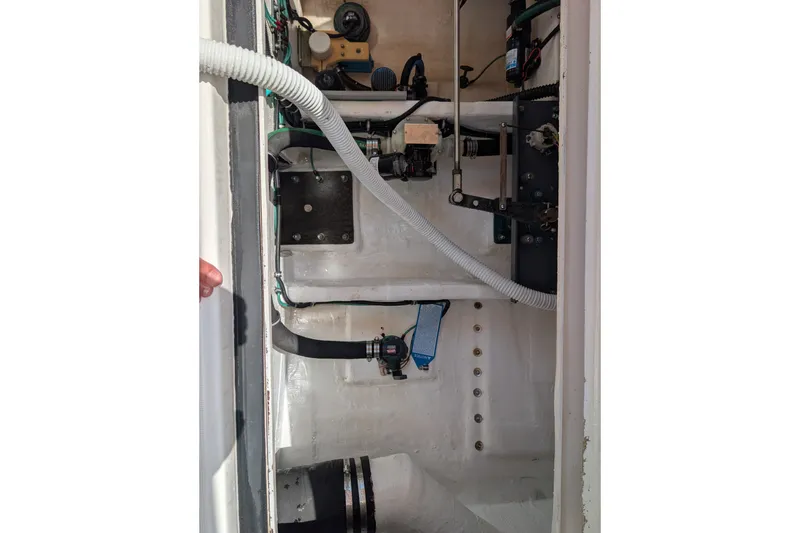 Slide: The Image of Interior view of a 2000 Pursuit 3400 Express boat's engine compartment, showcasing mechanical components. - 43