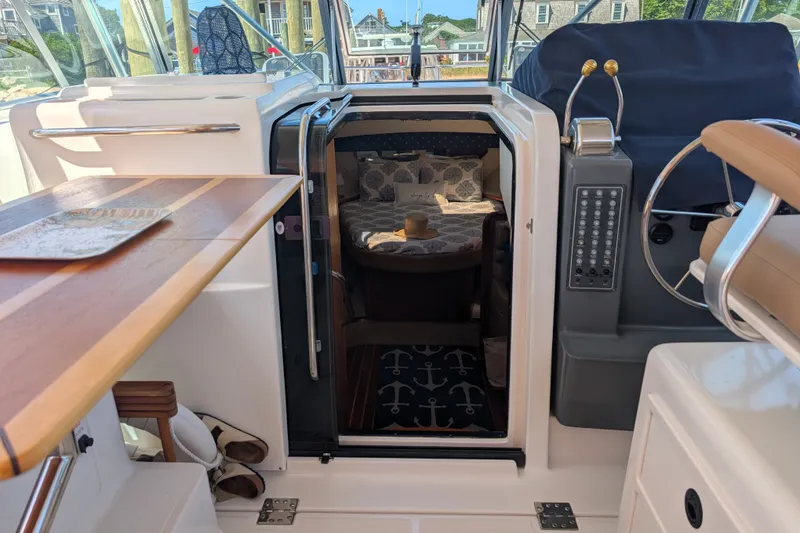 Slide: The Image of Interior view of a 2000 Pursuit 3400 Express boat, featuring a cozy cabin entrance. - 23