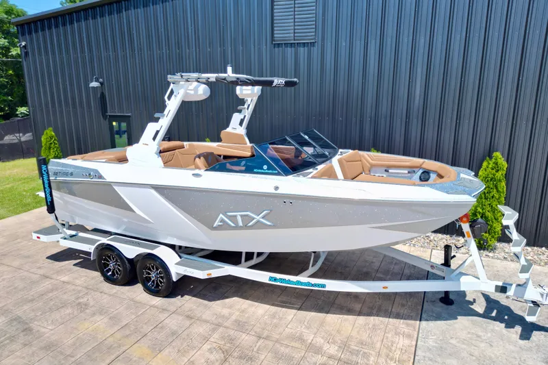 Slide: The Image of 2027 ATX Surf Boats 22 Type-S on trailer, parked outdoors near a black building. - 13