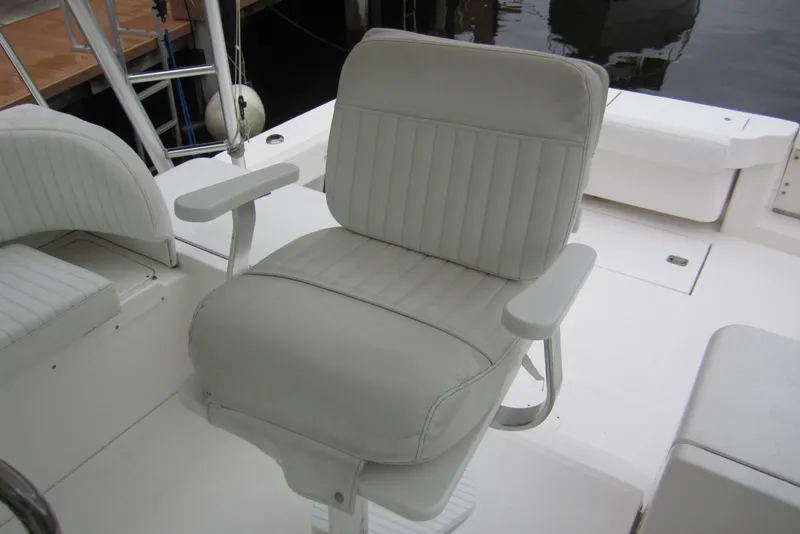 Slide: The Image of White captain's chair on 2005 Luhrs 32 Open boat deck, featuring cushioned armrests. - 13