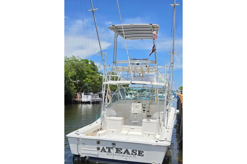 Slide: The Image of 2005 Luhrs 32 Open boat docked, featuring fishing equipment and a spacious cockpit. - 4