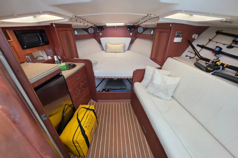 Slide: The Image of 2005 Luhrs 32 Open cabin interior with kitchenette, seating, and fishing gear. - 24
