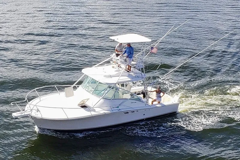 Slide: The Image of 2005 Luhrs 32 Open boat cruising on water with passengers onboard. - 0