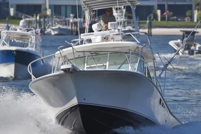 Slide: The Image of 2005 Luhrs 32 Open boat cruising on water with other vessels in the background. - 2