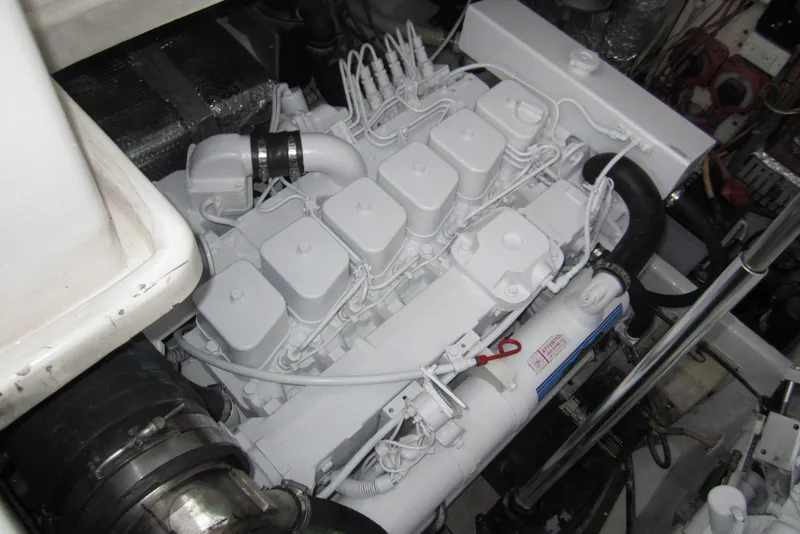 Slide: The Image of Engine compartment of a 2005 Luhrs 32 Open boat, showcasing a clean, white engine. - 37