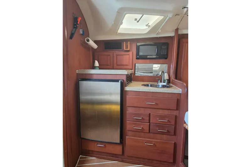 Slide: The Image of 2005 Luhrs 32 Open yacht interior kitchen with fridge, microwave, and sink. - 26